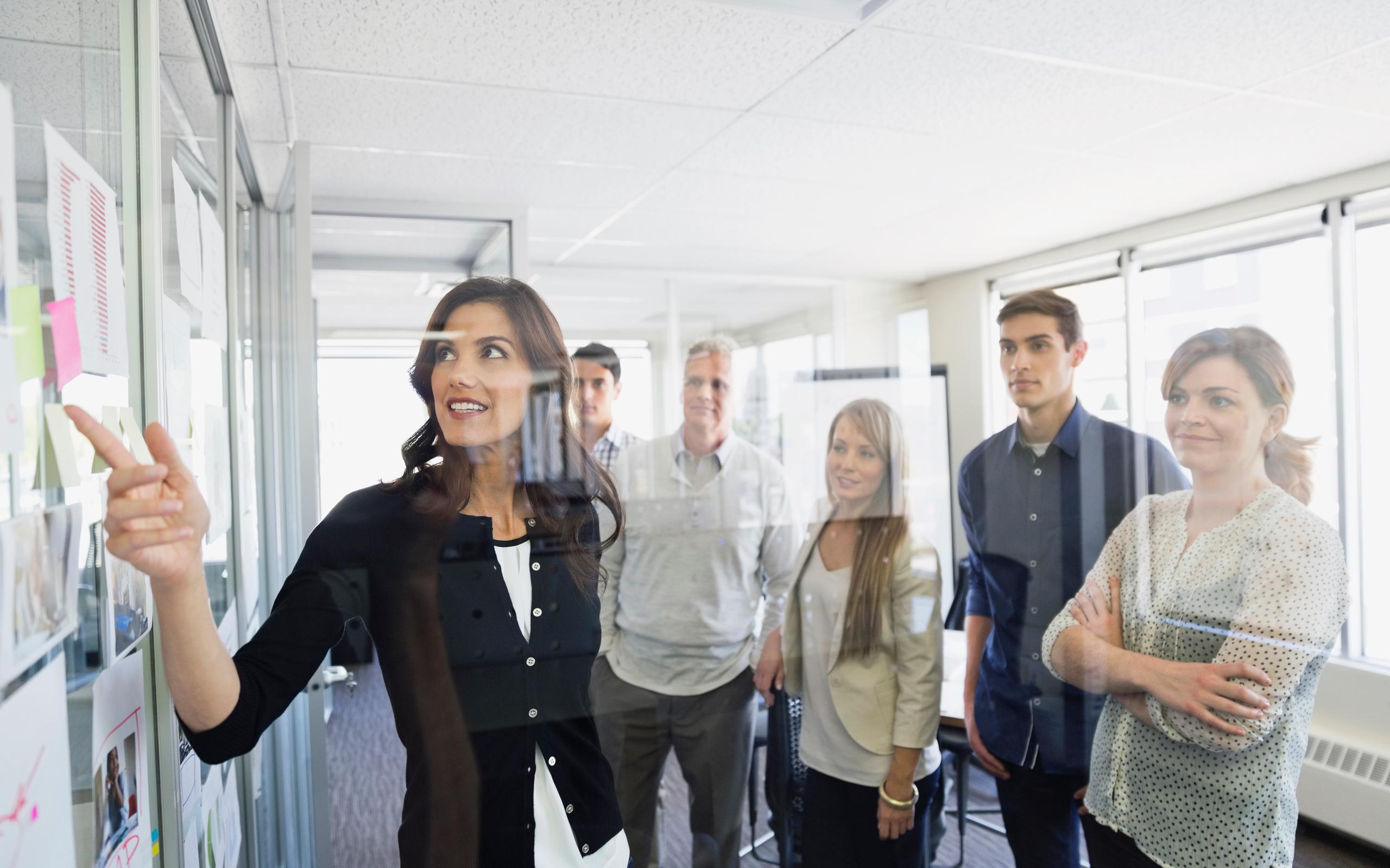 Businesswoman discussing project with colleagues in office