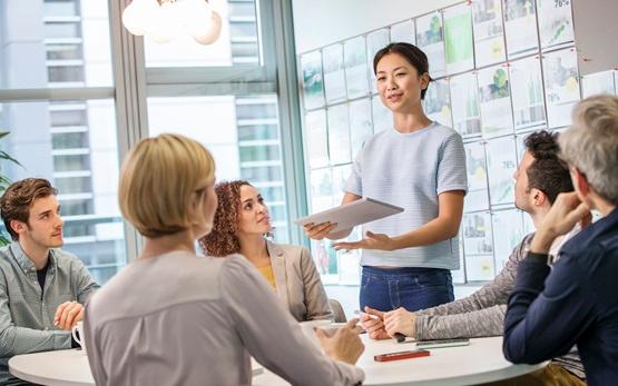 Female colleague explaining ideas to team at conference table