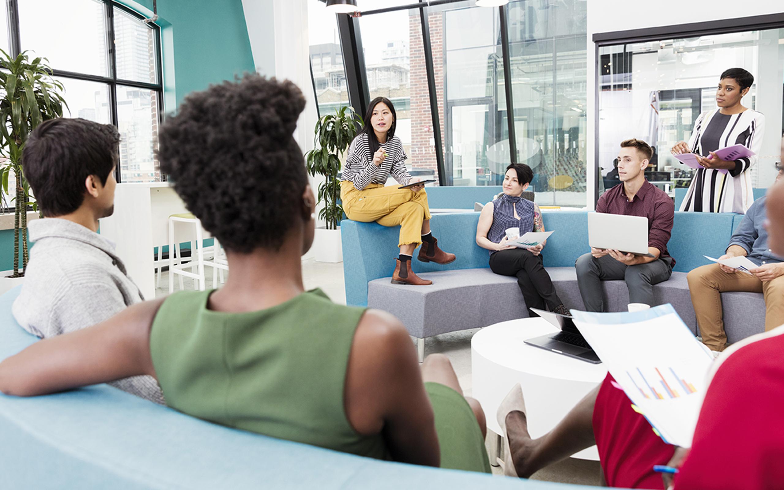 Businesswoman leading informal meeting in modern open plan office