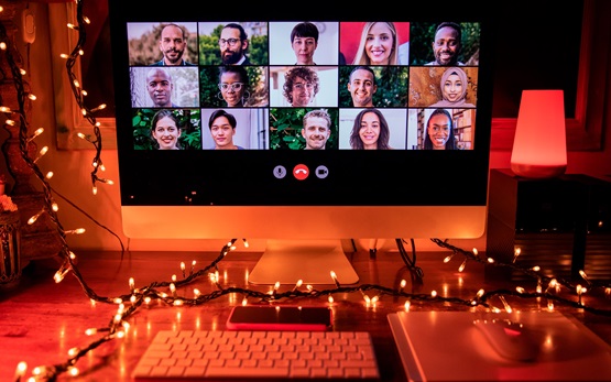 Video conference with many friends at night with fairy lights surrounding the computer screen and desk 