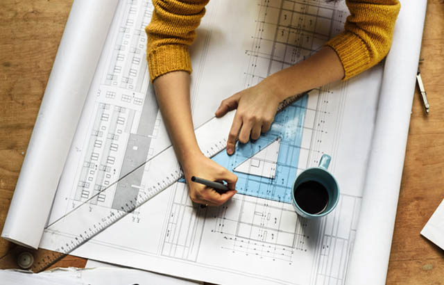 Architect measuring blueprints with a protractor and a ruler