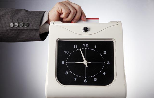 Hand putting time card into time clock