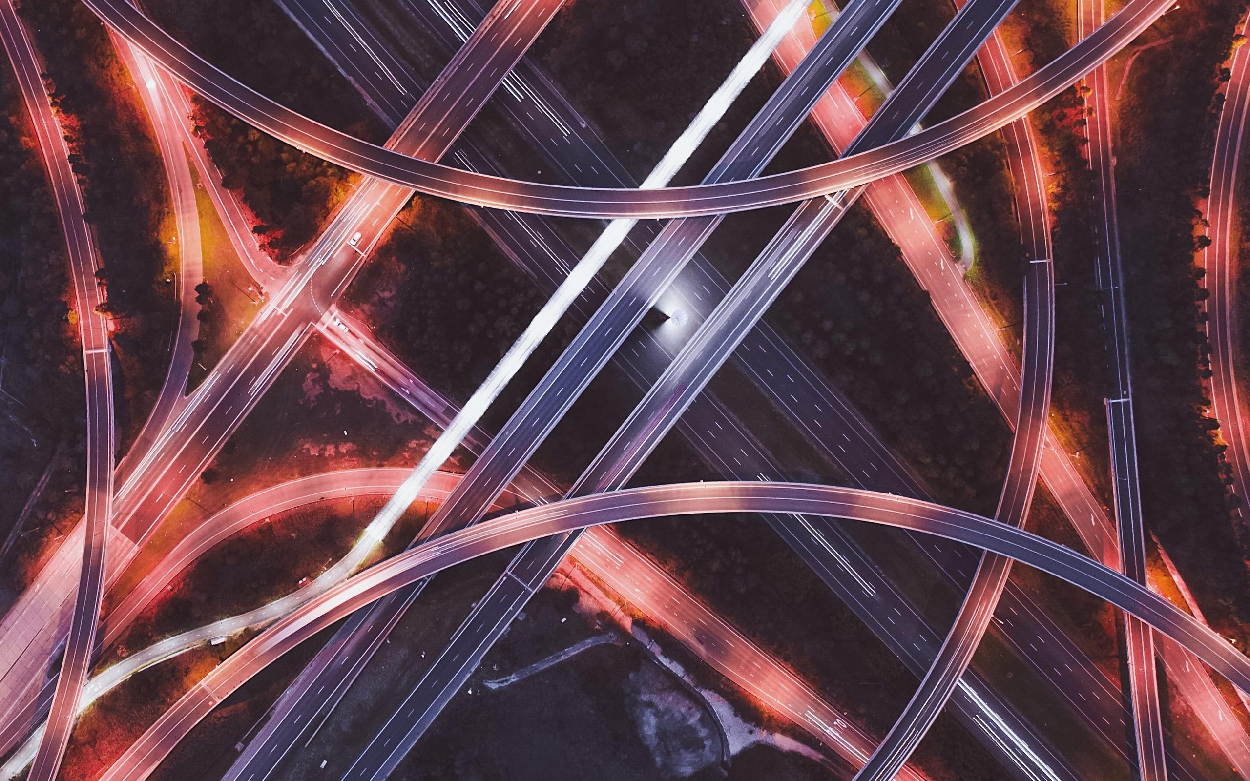 aerial view of intersecting roads at night with red lights