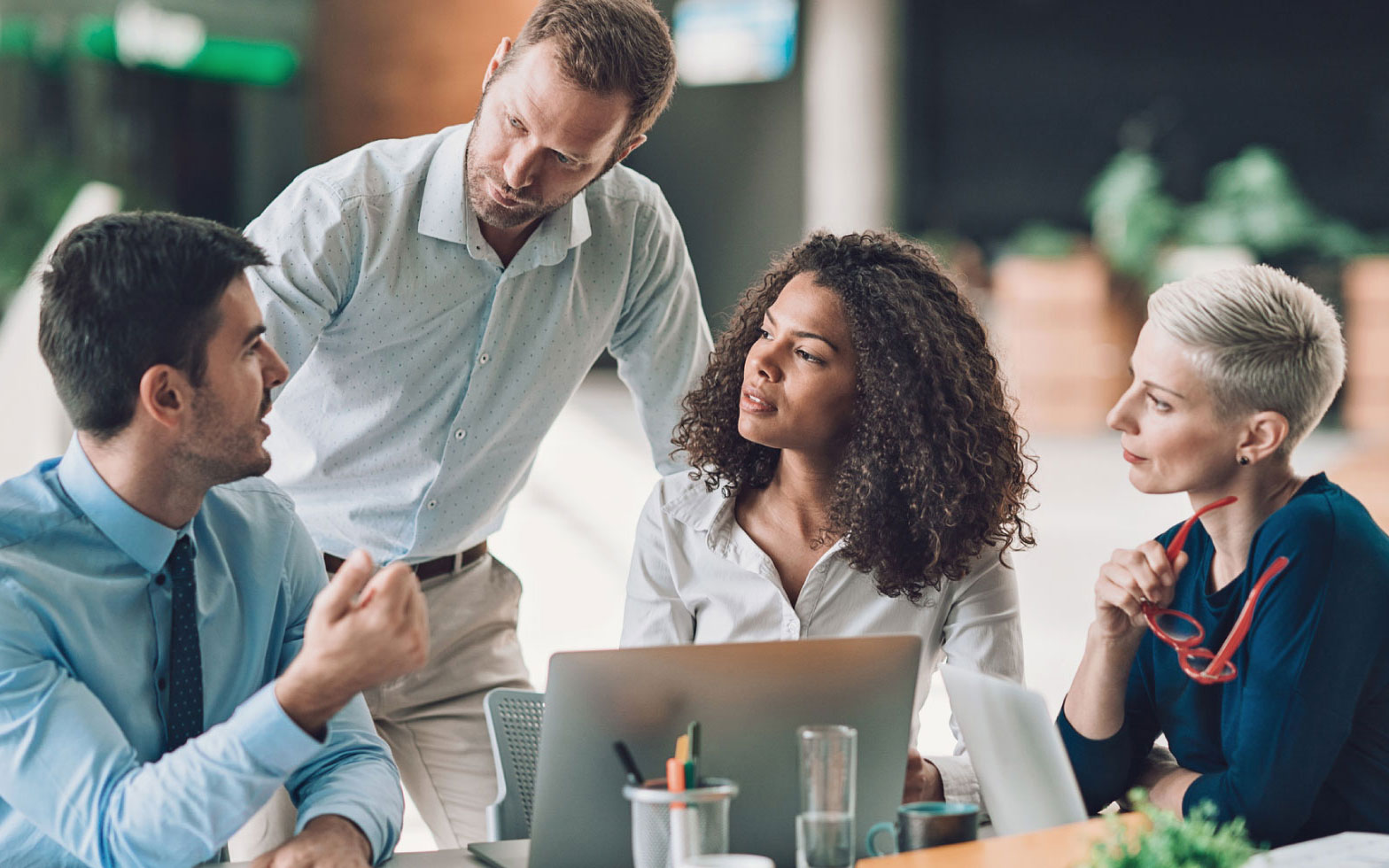 Business people around a laptop having a discussion.