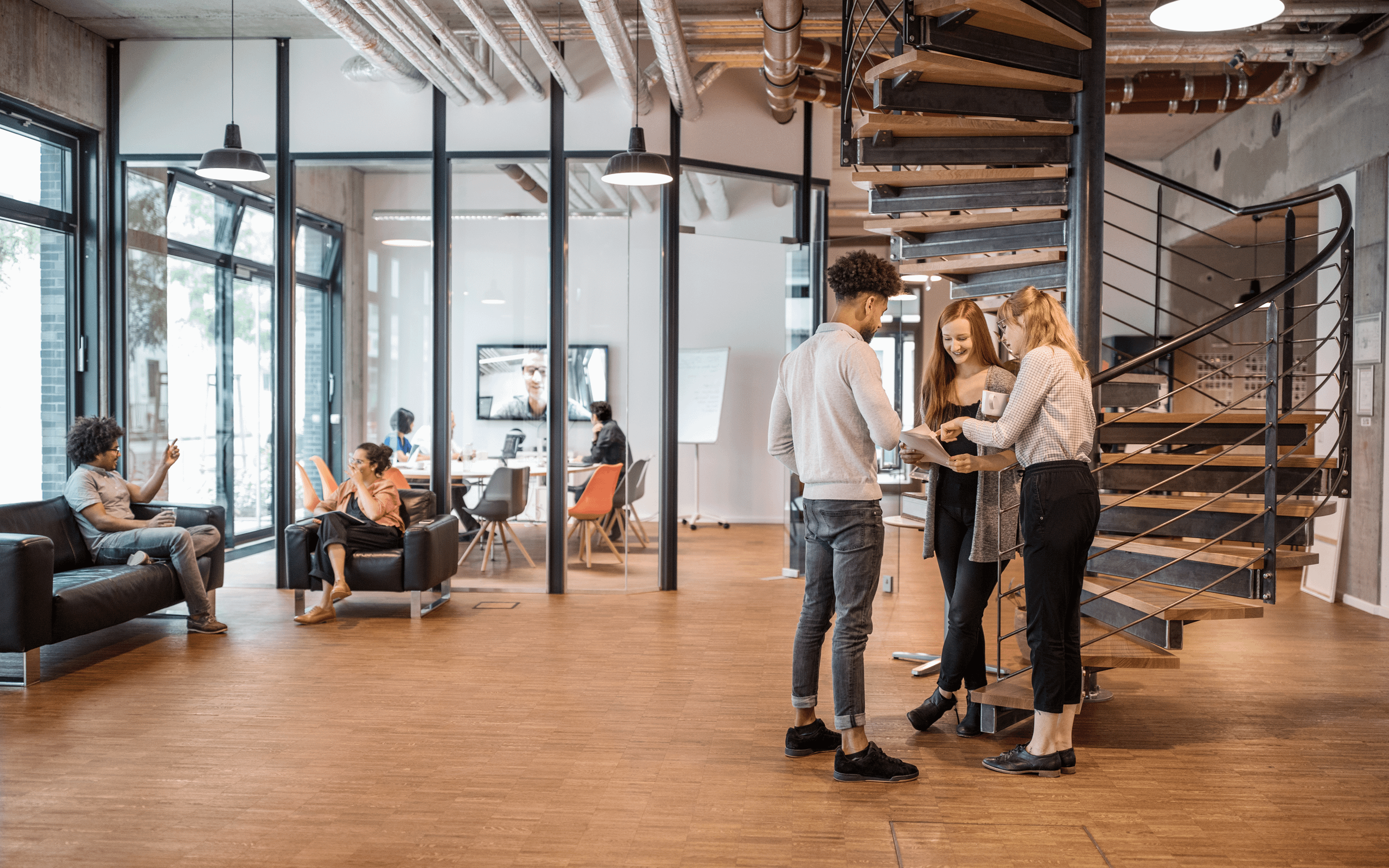 Three business people having a standing discussion in an open office 